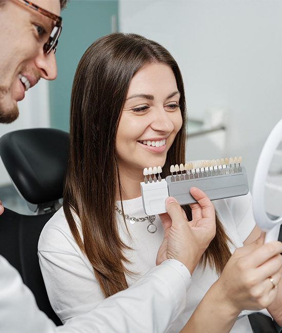 The image shows a dental professional assisting a patient with a dental device or appliance.